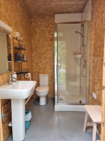 A well equipped shower room with a toilet, sink, and shower.