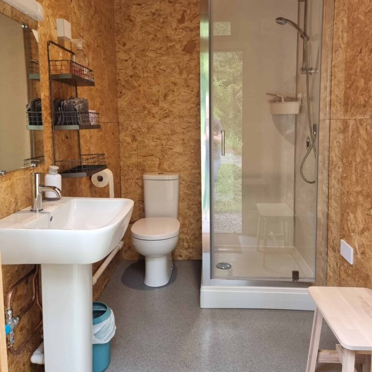 A well equipped shower room with a toilet, sink, and shower.
