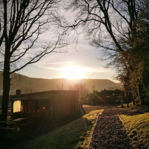 The sun rising over the roost cabins