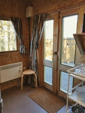 Cabin living area with french doors heater, stool, curtains